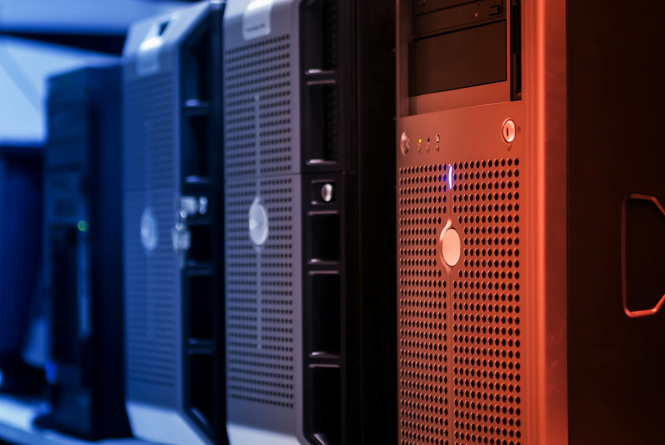 Close-up of tower servers in a data center with blue and red lighting.